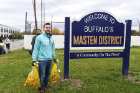 Tool Library founder Darren Cotton carries bags containing 500 daffodil bulbs to be planted along East Delavan Avenue and around the "Welcome to Buffalo's Masten District" sign. 