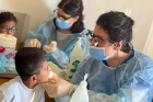 A child receives dental care from a volunteer.