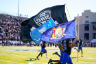 UB players take the field carrying flags representing New York State, UB and the MAC Conference. Photo: Marvin Gentry