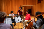 Parker violinist Daniel Chong demonstrates for the string quartet who were, from left, Owen Katz, viola (back to the camera); Thierry Huang, violin; Brandon Knox, violin; Christian Allen, cello.