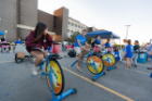 Students at Campus Fest, pedaling stationary bikes that blend smoothies. 