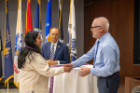 Dean of Students Tomas Aguirre presents a cord to a graduating student.