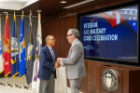 Director Dan Ryan presents President Tripathi a challenge coin.