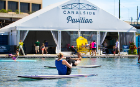People do yoga on paddleboards in Lake Erie in front of the Canalside Pavilion tent. 