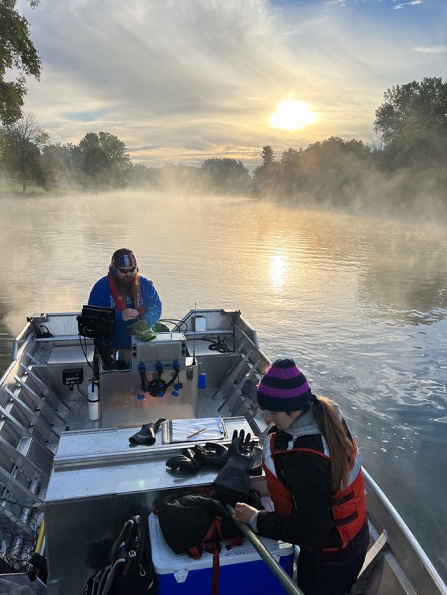Scientists on a boat conducting fieldwork in Tonawanda Creek. 