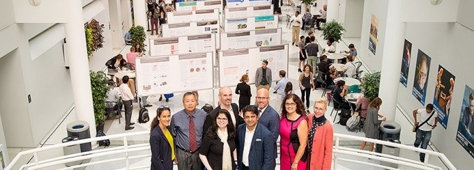 Zoom image: Leaders of the GEM, GHE and SMART Communities of Excellence get an overhead view the posters presented at the research institutes' annual progress review. Photo: Meredith Forrest Kulwicki 