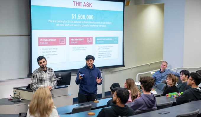 Students discussing entrepreneurship in a classroom. 