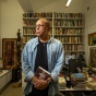 Portrait of Henry-Louis Taylor Jr. in his office, with bookshelves and a desk in the background. 