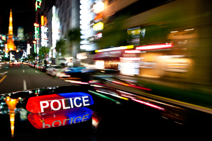 Police car speeding through an urban landscape at night. 