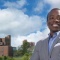 Michael Kwame Twum standing with UB buildings behind him in the distance. 