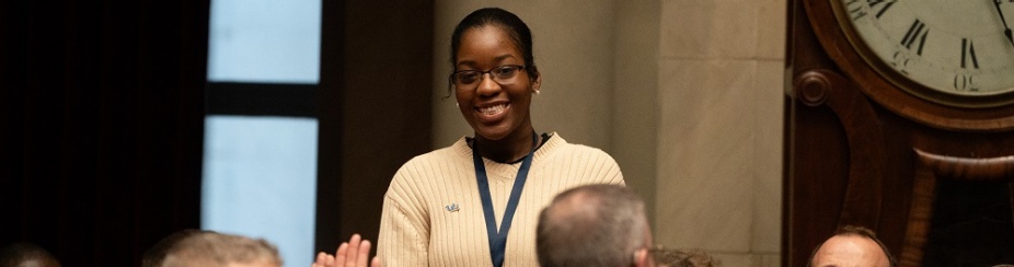 Holliday Sims, center, stands for applause at the State Capitol after being acknowledged by Gov. Kathy Hochul for her work using artificial intelligence for social good. 