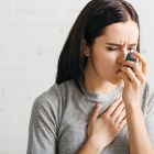 A sick woman using an inhaler. 