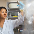 Zhen Wang in the lab holding a flask. 