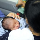 Infant being held by their mother. 