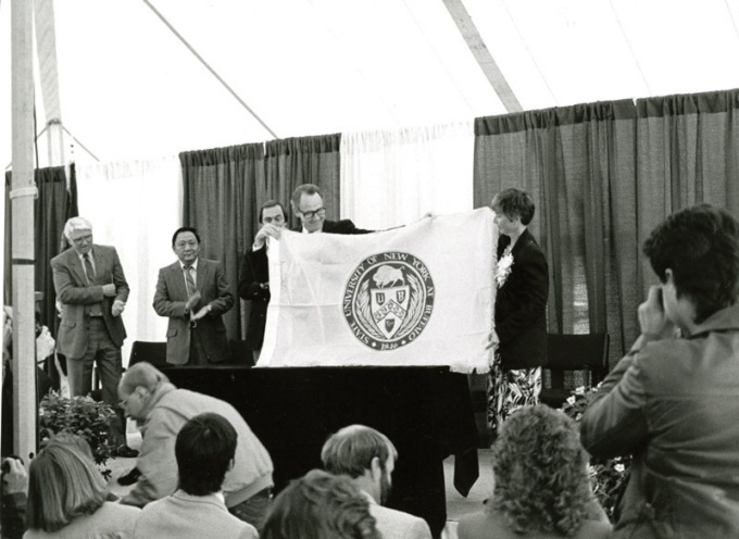 Marcia Jarvis and then UB President Steven Sample holding the flag that flew aboard the Challenger.