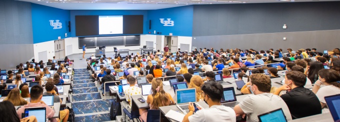 Faculty member teaching a class in a lecture hall. 