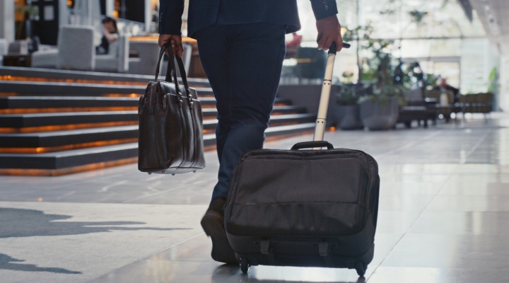Businessman, luggage and travel while walking in airport or station for company trip or international flight. Corporate person with international traveling, suitcase and employee in airport terminal. 
