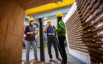 Students wearing hard hats on a construction site. 