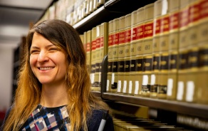 Students standing in front of books in the law library. 