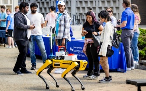 Students and using an AI robot dog. 