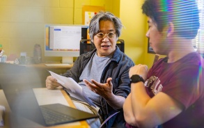 Student speaking with professor in office. 