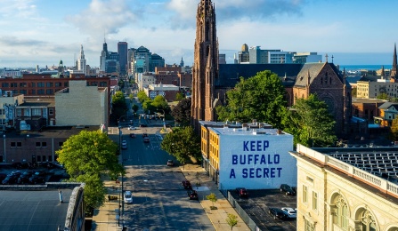 Aerial view of downtown Buffalo with a sign that reads, "Keep Buffalo a Secret.". 