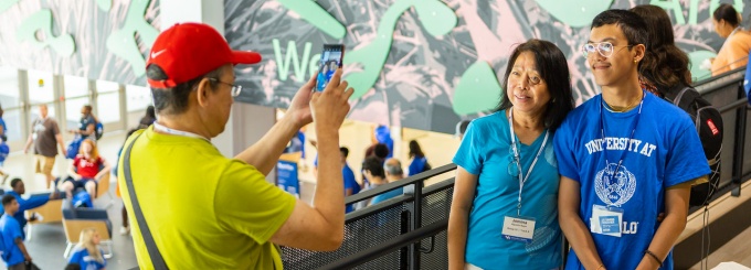 Parents taking a picture of their student during orientation. 