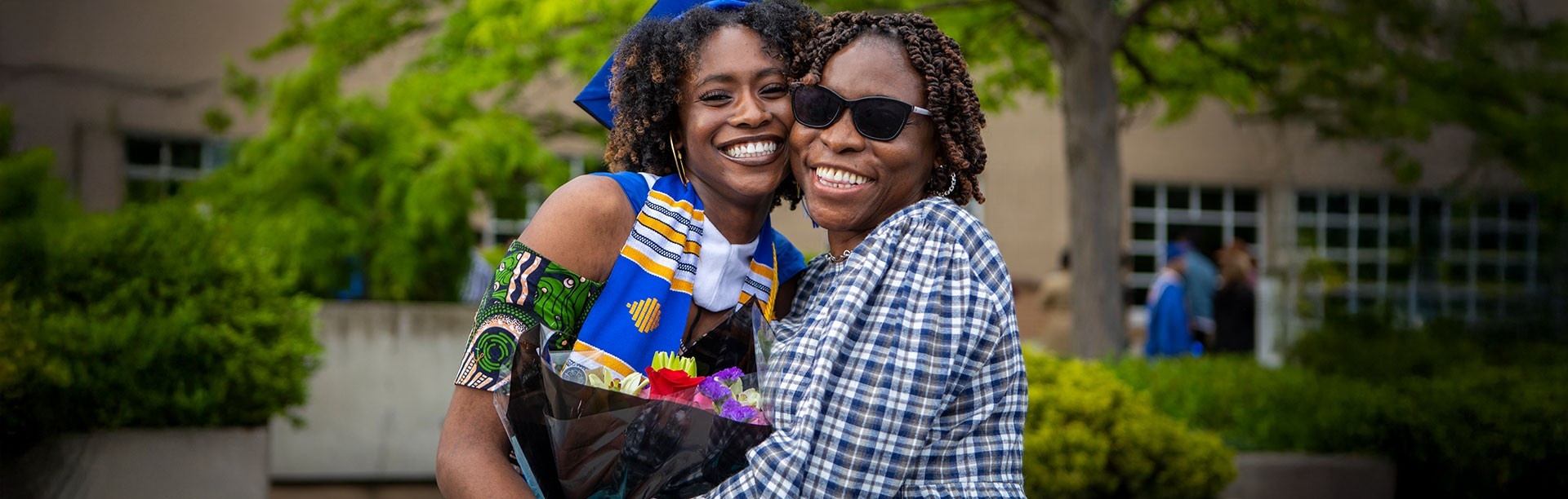 Parent and child hugging at graduation. 