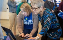 A University Advancement employee assisting a UB employee on a laptop. 