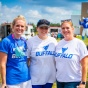 Three women wearing UB t-shirts outside the CFA during summer. 