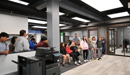 A group of students and teachers watch a presentation. 
