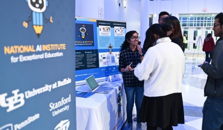 People viewing a technology demonstation at an AI Institute display table. 