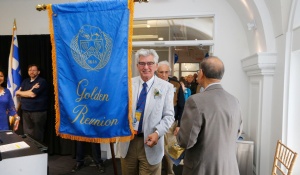 Guests arriving at Golden Reunion carrying a banner. 