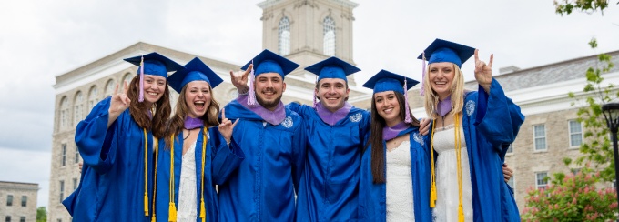 Graduates and their guests take photos near the Hayes Hall on South Campus in May 2024. 