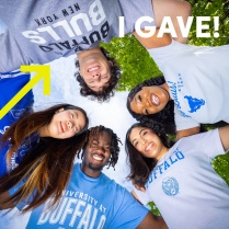 Zoom image: 5 UB students standing in a circle looking down into the cameara with 'I GAVE!' written in the corner. 