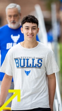 Zoom image: UB student smiling into the camera wearing a UB Bulls t-shirt 