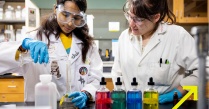 Zoom image: UB students in a chemistry lab mixing solutions 