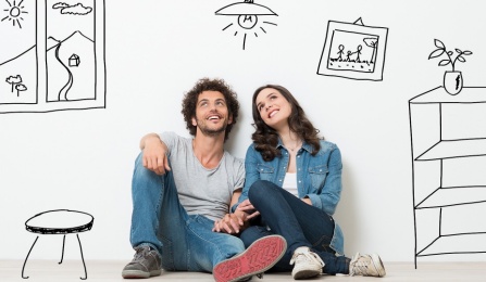 A man and woman sitting next to one another, hands interlocked. 