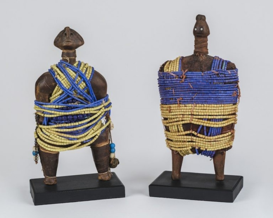Collage on selected African sculpture tied with blue and yellow beads straps forming like a clothing of each sculpture. 