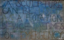 A painting on fabric with a blue and white background and the words "a sculpture can be used as a floatation device in times of emergency.". 