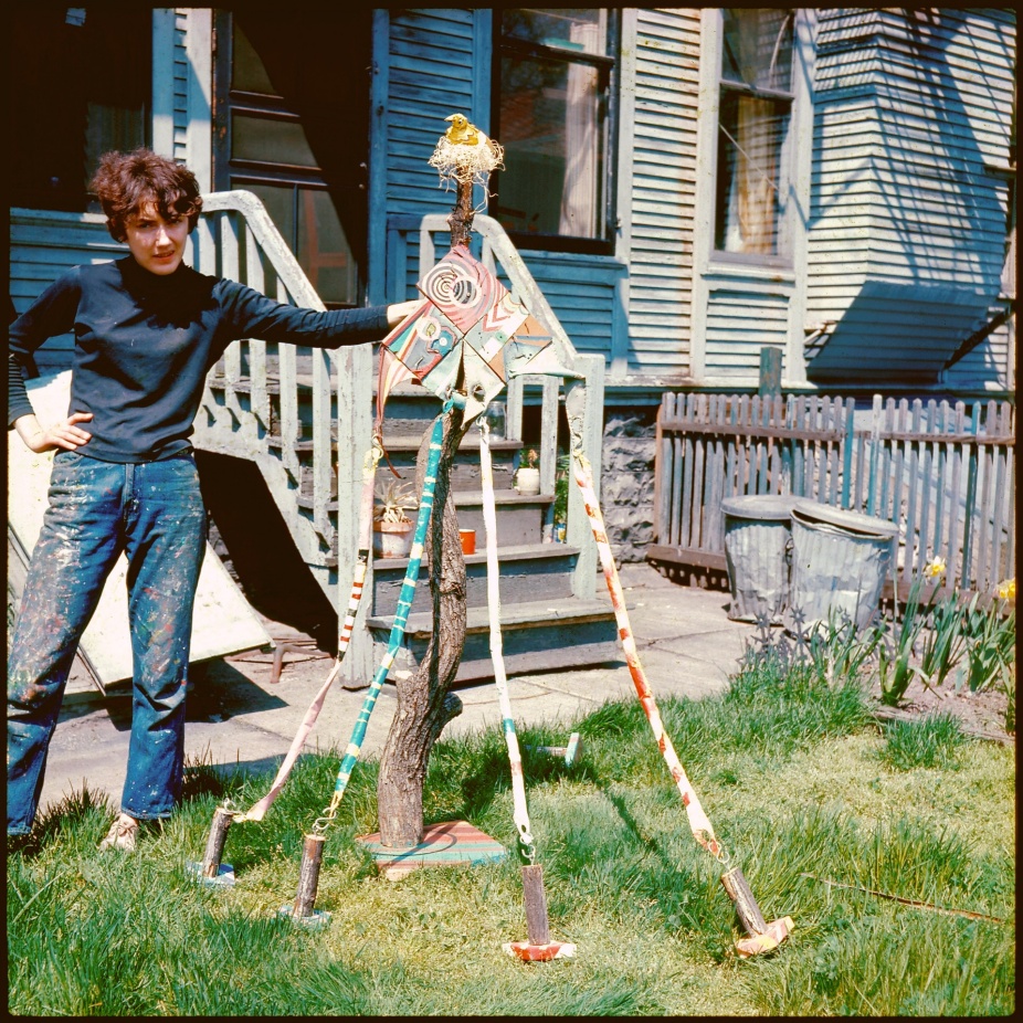 A photograph of Elizabeth Murray standing outside next to a sculpture she was working on. 