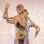 A photograph of Bridget Moser performing - a skeleton covered in fur, and a woman behind the skeleton positioning its arms. 