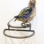photo of a sculpture by Christy Rupp, a bird made of metal fabric, and netting is yellow and resembles a goldfinch. 