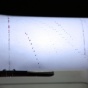 "A typewriter with paper loaded showing a piece of visual poetry, featuring the letter 'F' repeated in a diagonal descending pattern alongside scattered dot patterns in red and blue ink.". 