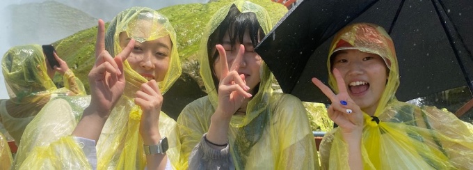 Korean students wearing yellow rain ponchos. 