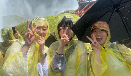 Korean students wearing yellow rain ponchos. 