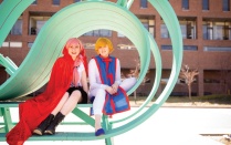 Shelby Jakubik (left) and Tatem Rogers sitting on a piece of public art on Founders Plaza. 