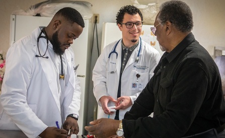 Black doctors consulting with a black patient. 