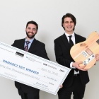 Students hold up a check and their invention as winners of the Panasci competition. 