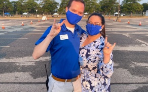 Residence life staff wearing masks giving the horns up sign. 